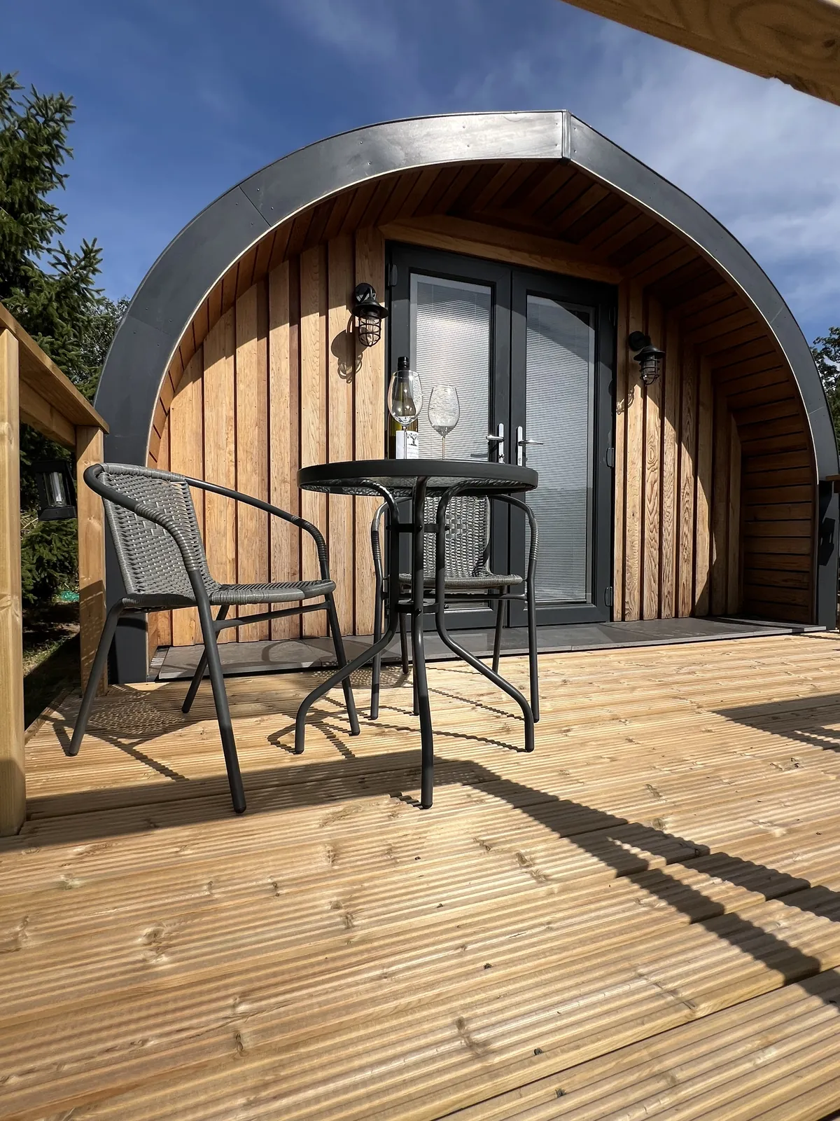 Table and two chairs on the decking outside the double doors