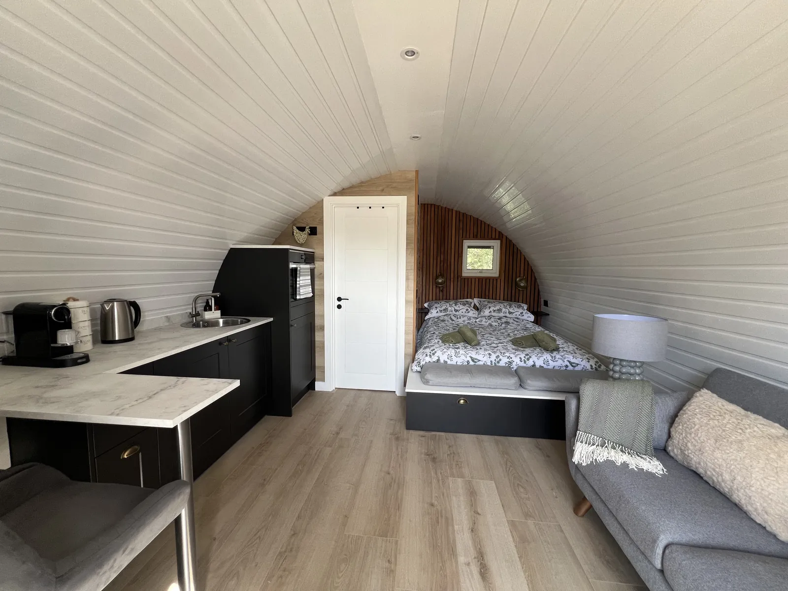 Inside the pod, with the kitchenette, sofa and king size bed