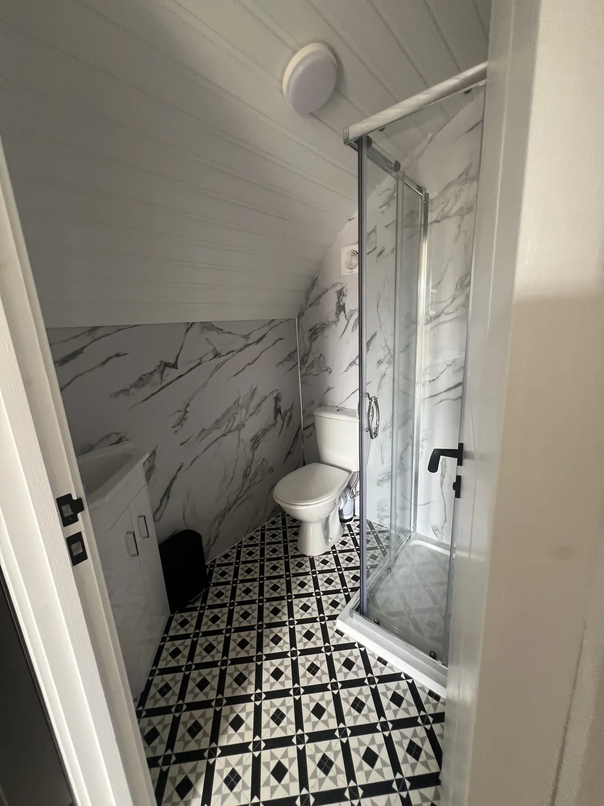 Shower room with toilet and patterned floor tiles